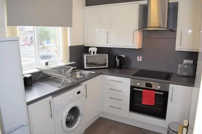 a kitchen with a sink and a washing machine at Kelpies Serviced Apartments Alexander- 2 Bedrooms in Falkirk