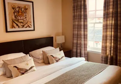 a bedroom with a bed with birds on the pillows at The Webstersland Residence in Edinburgh