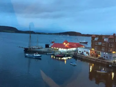 a marina with boats in the water at night at Argyll Mansions Penthouse in Oban