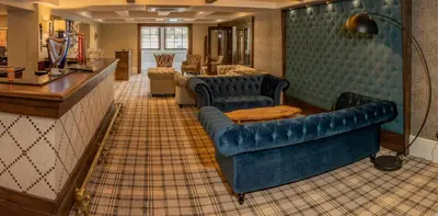 a living room with a blue couch and chairs at Crowwood Hotel and Alba Restaurant in Chryston