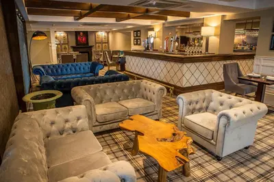 a living room with couches and chairs and a bar at Crowwood Hotel and Alba Restaurant in Chryston