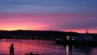 a person walking along a river at sunset at Sunnyside House in Rothesay
