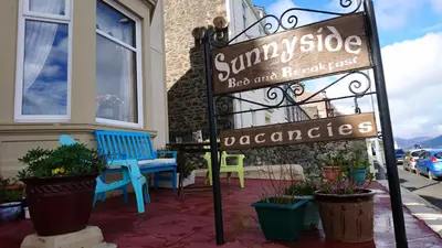 a sign on the sidewalk in front of a building at Sunnyside House in Rothesay