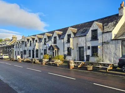 a row of houses on the side of a street at The White Stag Inn in Strathyre