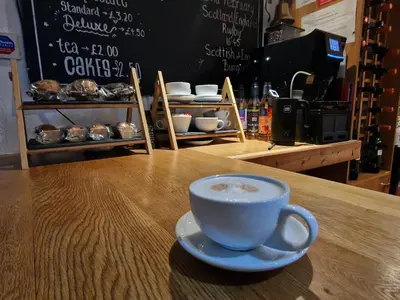 a cup of coffee sitting on top of a table at The White Stag Inn in Strathyre