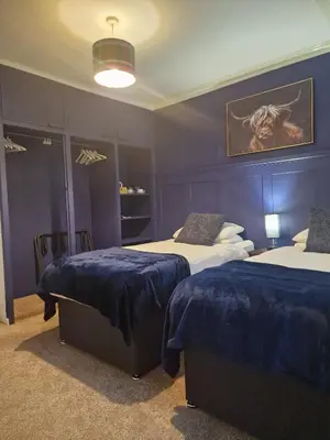 two beds in a room with blue walls at The White Stag Inn in Strathyre