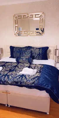 a bedroom with a bed with a mirror above it at Loch Lomond Apartments in Dumbarton