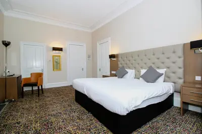 a hotel room with a large bed and a desk at City Apartments in Glasgow