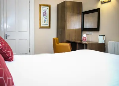 a room with a bed and a desk and a mirror at City Apartments in Glasgow