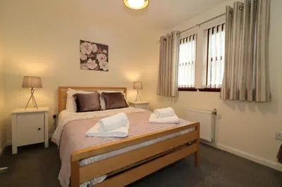a bedroom with a bed with two towels on it at Signature - Douglas View Blantyre in High Blantyre