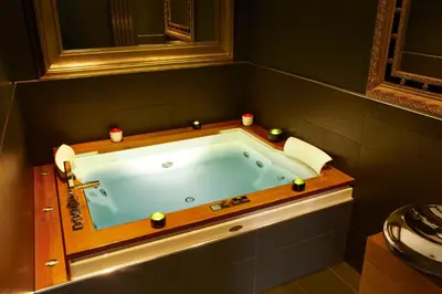 a bathroom with a bath tub with candles in it at Nira Caledonia in Edinburgh