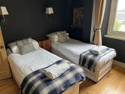 a bedroom with two beds with towels on them at The Castle Esplanade Residence in Edinburgh