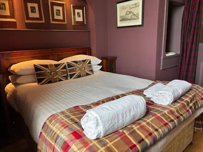 a bedroom with a bed with two towels on it at The Castle Esplanade Residence in Edinburgh
