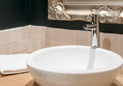 a white sink with a faucet in a bathroom at The Castle Esplanade Residence in Edinburgh
