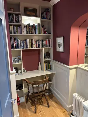 a book shelf with a desk and a chair at The Castle Esplanade Residence in Edinburgh