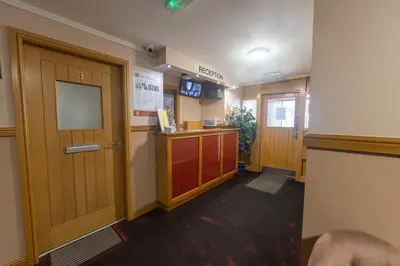 a hospital hallway with a door and a counter at Quay Head View Aparthotel in Stranraer