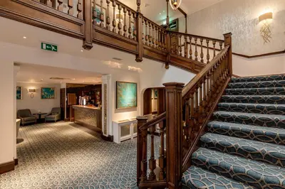 a spiral staircase in a building with a lobby at Western House Hotel At Ayr Racecourse in Ayr