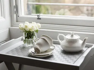 a table with a tea pot and a vase of white flowers at The Lane Hotel in Edinburgh