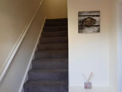 a staircase in a house with a picture on the wall at Workforce Property in Kirk of Shotts