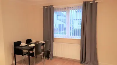 a dining room with a table and chairs and a window at Workforce Property in Kirk of Shotts