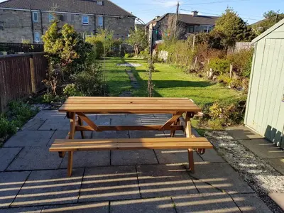 a wooden bench sitting on top of a patio at Workforce Property in Kirk of Shotts