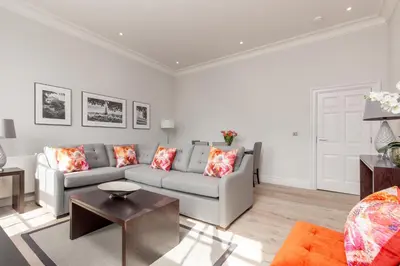 a living room with a couch and a table at Destiny Scotland - Chisholm Hunter Suites in Edinburgh