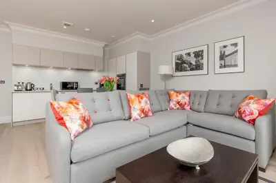 a living room with a gray couch and a table at Destiny Scotland - Chisholm Hunter Suites in Edinburgh