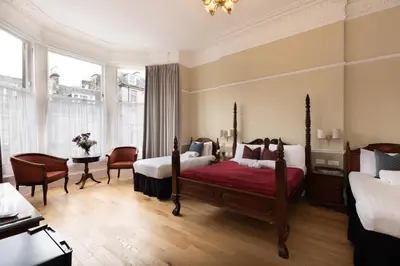 a bedroom with a bed and a table and chairs at The Haymarket Hotel in Edinburgh