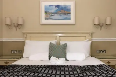 a bedroom with a large bed with white pillows at The Haymarket Hotel in Edinburgh