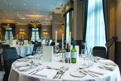a dining room with white tables with wine glasses at Holiday Inn - Glasgow - City Ctr Theatreland by IHG in Glasgow