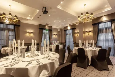 a conference room with white tables and chairs and chandeliers at Holiday Inn - Glasgow - City Ctr Theatreland by IHG in Glasgow
