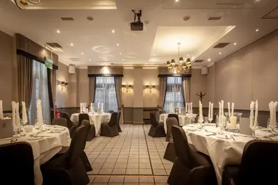 a room with tables and chairs with white table cloths at Holiday Inn - Glasgow - City Ctr Theatreland by IHG in Glasgow