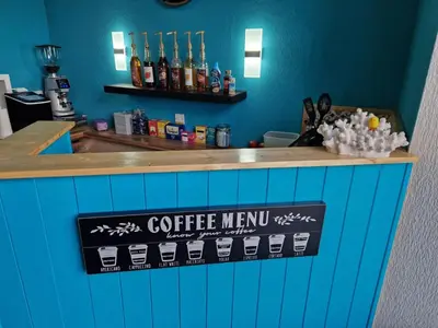 a blue counter with a coffee menu sign on it at Commodore Guesthouse, Seaside Holiday Suites in Rothesay