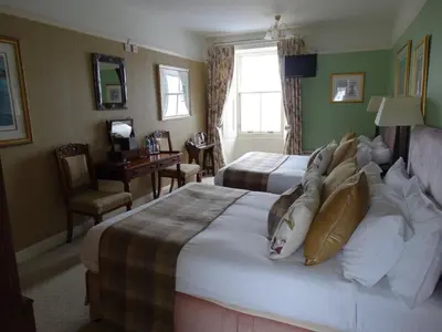 a hotel room with two beds and a desk at Port Charlotte Hotel in Port Charlotte