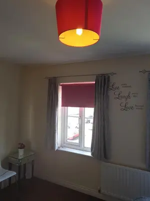 a bedroom with a window with a red curtain at Livingston 4 bedroom townhouse in Livingston