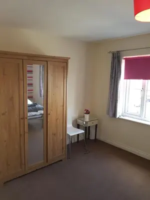 a room with a cupboard and a bed and a window at Livingston 4 bedroom townhouse in Livingston