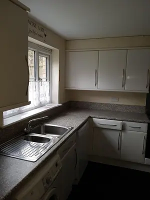 a kitchen with white cabinets and a sink and a window at Livingston 4 bedroom townhouse in Livingston