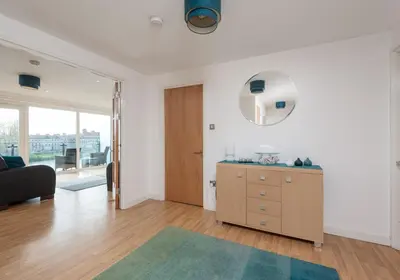 a living room with a dresser and a mirror at The Metropole Residence in Glasgow