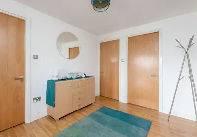 a bedroom with a dresser and a mirror at The Metropole Residence in Glasgow