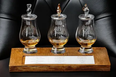 three bottles of whisky on a wooden tray at Angels Share Hotel in Edinburgh