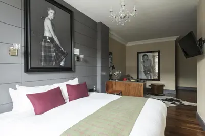 a bedroom with a large white bed with red pillows at Angels Share Hotel in Edinburgh