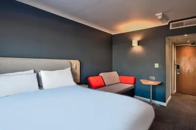 a hotel room with a bed and a couch at Holiday Inn Express Edinburgh City West by IHG in Edinburgh