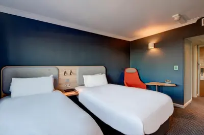 a room with two beds and a table and a chair at Holiday Inn Express Edinburgh City West by IHG in Edinburgh