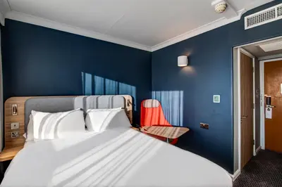 a bedroom with a bed and a blue wall at Holiday Inn Express Edinburgh City West by IHG in Edinburgh