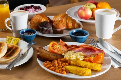 a table with plates of breakfast food on it at Holiday Inn Express Edinburgh City West by IHG in Edinburgh