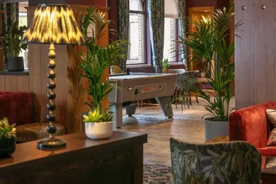 a living room with a desk and potted plants at Glasgow Westerwood Hotel, Spa & Golf Resort in Cumbernauld