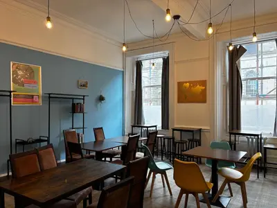 a dining room with wooden tables and chairs at Safestay Glasgow Charing Cross in Glasgow