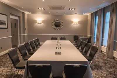 a conference room with a long table and chairs at Rosslea Hall Hotel in Rhu
