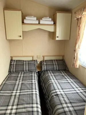 two beds sitting next to each other in a room at Curacao Caravans in Taynuilt