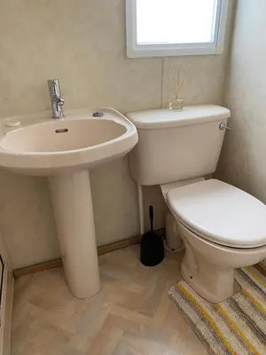 a bathroom with a toilet and a sink at Curacao Caravans in Taynuilt